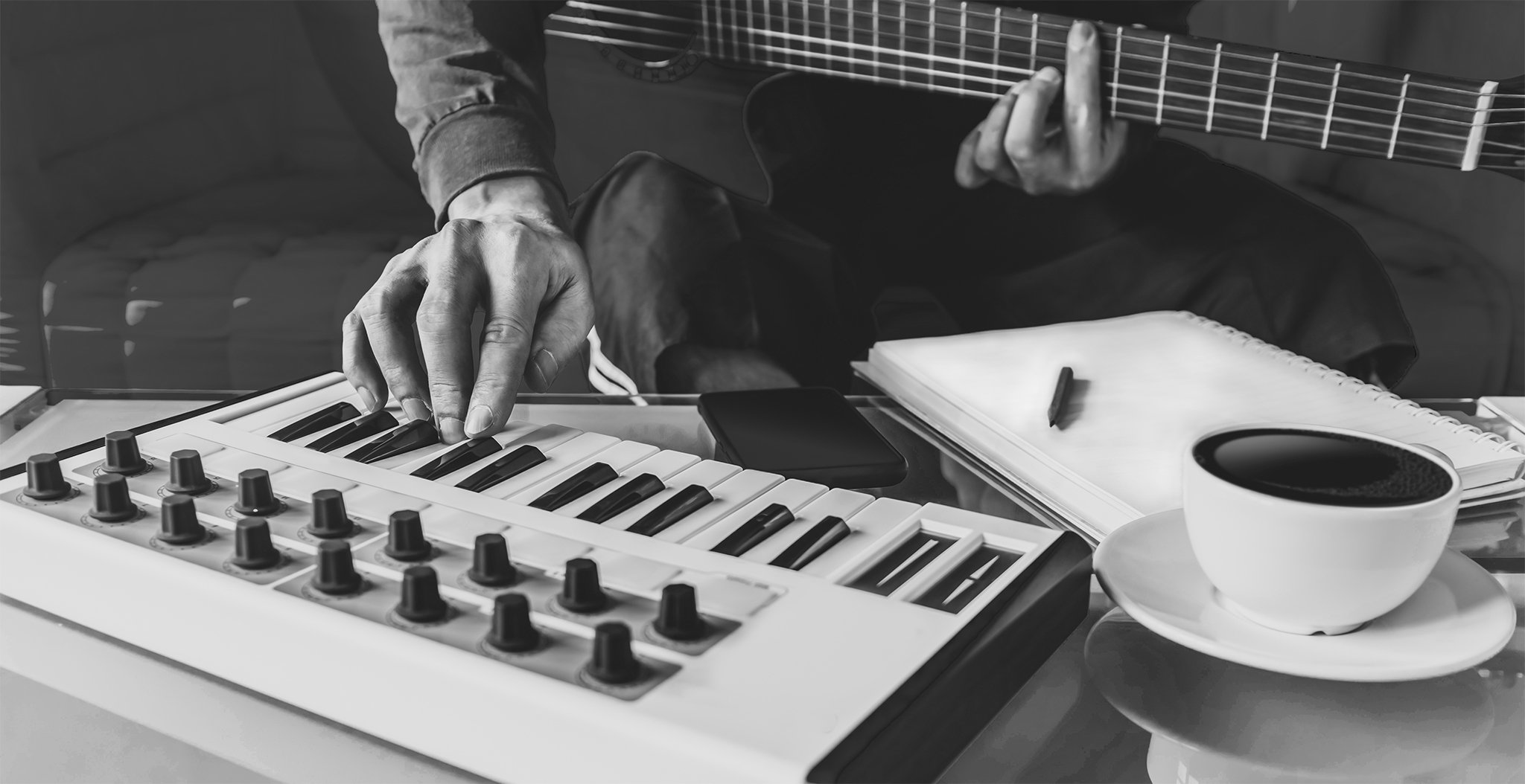 hand on guitar and hand on keyboard